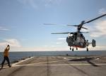 Civil service mariner Boatswain's Mate Anthony Brooks directs a Kamov (KA 26) Helix Soviet navy helicopter for takeoff aboard USS Mount Whitney (LCC/JCC 20).