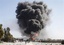 Smoke from a burning truck raises outside a NATO military base during an anti-US protest in Jalalabad, east of Kabul, Afghanistan, Wednesday, Feb. 22, 2012.