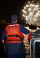 BOSTON (July, 4, 2005) A member of Coast Guard Station Boston's Harbor Defense Team maintains a sharp lookout during the Fourth of July fireworks show Monday in the Charles River, Boston. For many, July fourth is a day to celebrate our nation's independence and freedom. For members of Harbor Defense, it is a reminder that freedom isn't free. To provide public safety and security during the show, Coast Guard Station Boston deployed two 25-foot response boats, each with four-man crews who were on