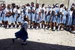 A girl runs by a line of her classmates. Military contingents from the United Nations Mission in Haiti joined forces to hold a CIMIC day for local residents and students in Haiti's capital Port au Prince's Bel Air neighbourhood. Doctors, dentists and engineers were in attendance at an all girls school, providing medical and dental attention and cleaning the surrounding streets of garbage and debris. Photo Logan Abassi UN/MINUSTAH