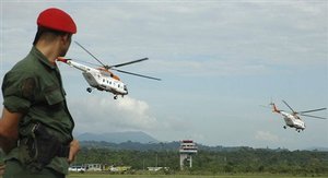 A soldier watches two helicopters leave the airport in Santo Domingo, Venezuela, Friday, Dec. 28, 2007, as they depart for Villavicencio, Colombia, which is to be the air base for coordinating the release of three hostages held by the Revolutionary Armed Forces of Colombia, or FARC. The hostages' release is expected within hours. (js1)