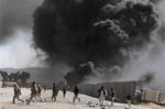 Protestors run as smoke raises from a burning truck during an anti-US demonstration at a NATO military base in Jalalabad, east of Kabul, Afghanistan, Wednesday, Feb. 22, 2012. Anti-American demonstrations continued for a second day Wednesday in Afghanistan over what the U.S. has said was the inadvertent burning of Muslim holy books at a NATO military base. (AP Photo/Rahmat Gul)