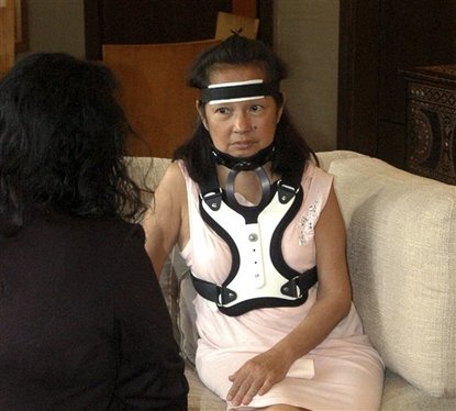 FILE - In this Tuesday Nov. 8, 2011 file photo, former Philippine President Gloria Macapagal Arroyo, wearing a head and neck brace, sits down for an interview with a local reporter at her residence in suburban Quezon city, northeast of Manila, Philippines.