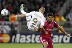 Real Madrid's Karim Benzema, left, challenges for the ball with Lyon's Ederson, right, during their Champions League soccer match at Gerland stadium, in Lyon, central France, Wednesday, Nov. 2, 2011