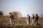 SAFAR, Helmand province, Afghanistan — U.S. Marine Lance Cpl. Zachary Fisher, a 22-year-old fire team leader with 3rd Platoon, India Company, 3rd Battalion, 3rd Marine Regiment and Roanoke, Va. native, walks through a field while Afghan National Army soldier Baran Gul and an interpreter greet a farmer during a partnered security patrol here, Dec. 30. On the patrol, the ANA and Marines interacted with local citizens and spoke with an elder about biometrically enrolling the members of his village