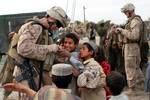 U.S. Marine Master Sergeant Carl Zador, 9th Engineer Support Battalion (9th ESB), 2d Marine Logistics Group Forward (2d MLG Fwd), interacts with Afghan children near Patrol Base Atull, Helmand Province, November 20, 2011. (U.S. Marine Corps photo by Lance Cpl. Gonzalez, Jessica S.)