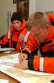 NEW YORK, New York (Oct. 30, 2002)) -- Petty Officer 2nd Class Jason Moberly plots a search pattern for a fictitious sailing vessel during ready-for-operations drills at Station New York as Seaman Sara Rosato converts latitude and longitude minutes to seconds here Oct. 30, 2002. USCG photo by PA3 Mike Hvozda (85238) ( PEOPLE (FOR RELEASE) )