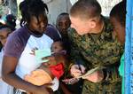 ance Cpl. Benjamin Rauschenberg, a linguist from the 22nd Marine Expeditionary Unit (22nd MEU), helps a young Haitian woman fill out her immunization card at a clinic.