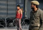 A kashmiri muslim boy infront of razore wire during a curfew in Srinagar on December 06,2011.