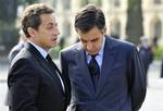 French President Nicolas Sarkozy, left, speaks with French Prime Minister Francois Fillon, right, during a ceremony to commemorate the 65th anniversary of the Allied victory over Nazi Germany, in Paris, France, Saturday, May 8, 2010.