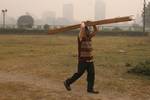 A man carry wooden stick on his forehead on a foggy morning in Kolkata on Wednesday,21 January 2011 Thick fog across East India