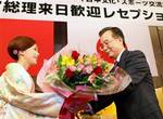 In this photo released by China's Xinhua News Agency, Japanese actress Noriko Sakai presents a bunch of flowers to Chinese Premier Wen Jiabao