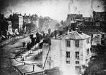 Boulevard du Temple, Paris, Spring 1838, by Daguerre (includes the earliest reliably dated photograph of a person). The image shows a busy street, but because the exposure time was at least ten minutes the moving traffic cannot be seen.