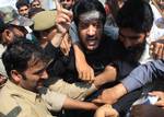 Chairman of Kashmir's Democratic Freedom Party Shabir Shah (C) in black) shouts slogans from the back of a police vehicle after being detained with other activists in Srinagar on July 13, 2011. Authorities in Indian Kashmir deployed thousands of security personnel in the main city of Srinagar to prevent separatist protests on a key state holiday, officials said. July 13 is marked in Indian Kashmir as 'Martyrs' Day', which marks Maharaja Hari Singh's use of force in 1931 to quell protests against