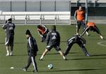 Real Madrid player Ronaldo, second right, performs some exercises as his coach Fabio Capello, second left, passes by while standing amid his teammates, David Beckham, left, Mahamadou Diarra, third left, Cassano, center, Robinho, third right, and Miguel Torres, right, during their training session in Madrid, Wednesday, Jan. 24, 2007. Ronaldo's prospective move to AC Milan moved closer after Real Madrid began negotiations with the Italian club. News reports said Wednesday that Madrid won't allow R