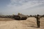 An Israeli soldier directs an army vehicle at a gathering area near the border with the Gaza Strip, in southern Israel,Tuesday, March 13, 2012.