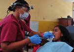 Dr. Kimberley Gise extracts a tooth during a Continuing Promise 2011 medical community service project.