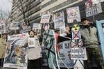 South Korean Vietnam War veterans and conservative activists with defaced photos of North Korean leader Kim Jong Il and his youngest son Kim Jong Un shout slogans during a rally denouncing leader Kim's birthday in Seoul, South Korea, Wednesday, Feb. 16, 2011.