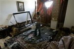 A Syrian boy, removes belongings from his family destroyed house, near the scene where a car bomb blew up in a southern neighborhood near the junction to the city's international airport, in Damascus, Syria, Saturday Sept. 27, 2008. A car packed with explosives detonated on a crowded residential street Saturday, killing 17 people and wounding more than a dozen others, state-run television reported. The car packed with 440 pounds of explosives blew up on Mahlak Street, shattering apartment building and car windows and twisting the roof of one car, according to footage aired on Syrian TV. Syrian Interior Minister Bassam Abdul-Majid called the bombing a "terrorist act" and said all of the victims were civil