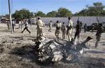 Somali government forces attend the scene of a car bomb in Mogadishu, Somalia Tuesday, Oct. 18, 2011. A suicide car bomb exploded near Somalia's Foreign Ministry on Tuesday, killing at least four people including the bomber, a police official said, on the same day that Kenya's ministers of defense and foreign affairs are in Mogadishu to meet with government leaders after Kenya on Sunday launched military operations in southern Somalia against al-Shabab militants. (AP Photo/Mohamed Sheikh Nor)