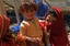 File - An Afghan girl takes care of her sister at a greenhouse near Qalat, Zabul province, Afghanistan, May 8, 2011.