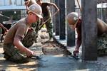 U.S. Navy Seabee's Builder Constructionman 3 Patrick McGonigal, left, and Builder Constructionman 3 Ian Tillman right, both with Naval Mobile Construction Battalion Forty smooth concrete at the construction site of a multi-purpose building being erected at the Wat Chalheamlap School in support of exercise Cobra Gold 2012, Chon Buri, Kingdom of Thailand, Jan. 25, 2012. Cobra Gold provides a unique and dynamic training opportunity for participating military partners while also promoting relationsh