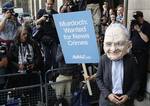 A protestor wearing a Rupert Murdoch mask is photographed by media outside parliament in London, Tuesday, July 19, 2011. Britain's Conservative Party says a former News of the World executive may have given the prime minister's former communications chief advice before the 2010 national election. The Conservative Party said Neil Wallis, who was arrested last week in Britain's phone hacking scandal, 