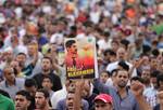 Bahraini anti-government protesters shout slogans and raise an image of jailed human rights activist Abdulhadi al-Khawaja on Friday, April 6, 2012, in Jidhafs, Bahrain, on the outskirts of the capital of Manama, during one of two simultaneous mass demonstrations supporting the imprisoned hunger-striker.