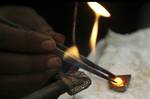 An Indian goldsmith melts gold before crafting it into jewelry in Jammu, India, Tuesday, Aug. 9, 2011. Gold continued to sprint for the seventh trading session and breached the crucial level of 25,000 rupees per 10 grams for the first time at the domestic bullion market here Tuesday, according to a news agency. Investors have turned to gold as the appeal of the dollar, the world's biggest reserve currency and traditionally a safe bet for investors, has ebbed. Gold’s value, unlike that of a curre