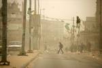 Palestinians walk at a street during cold winds and sand storms in the southern Gaza Strip town of Rafah on February 8, 2012. Photo by Photo by Ahmed Deeb/WN