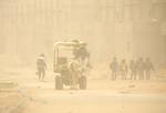 Palestinians walk at a street during cold winds and sand storms in the southern Gaza Strip town of Rafah on February 8, 2012. Photo by Photo by Ahmed Deeb/WN