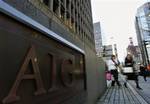 Women walk in front of the AIG building in Tokyo, Japan, Thursday, March 19, 2009.