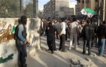 A Free Syrian Army fighter stands guard during the funeral for four people killed in a raid by government forces in a neighborhood of Damascus, Syria, Thursday, April 5, 2012.