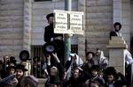 Ultra-Orthodox Jewish men gather around a sign that reads in Hebrew: 