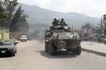 An Light Armored Vehicle (LAV) assigned to 2nd LAR BN passes by a local AIDS clinic in Port-Au Prince, the capital city of Haiti.