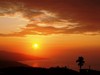 A sunrise with the typical orange color in the sky (south beach of Jamaica). The intense red and orange hues of the sky at sunrise and sunset are mainly caused by scattering of sunlight by dust particles, soot particles, other solid aerosols, and liquid aerosols in the Earth's atmosphere