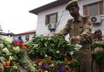 An indian policeman laying a wreath on the coffin containing the body of slain assistant sub inspector of police (ASI} Sukhpal Singh during the funeral ceremony in Srinagar, 20, April, 2012.