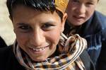 A young boy and his friends play outside the Danesh Center educational facility in Ghazni City as members of Provincial Reconstruction Team Ghazni unload computers to be donated to the facility.