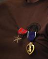 The Bronze Star with Valor and the Purple Heart medals hang from Explosive Ordnance Disposal Technician 2nd Class Andrew Bottrell's shirt.