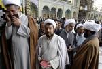 Mojtaba Zolnouri, a former top official with Iran's elite Revolutionary Guard, left, talks on his mobile phone as the other clerics queue to cast their ballots during the parliamentary elections at Masoumeh shrine in the city of Qom, 78 miles (125 kilometers) south of the Tehran, Iran, Friday, March 2, 2012. The balloting for the 290-member parliament is the first major voting since the disputed re-election of President Mahmoud Ahmadinejad in June 2009 and the mass protests and crackdowns that f