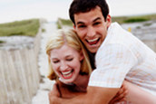 Laughing couple with girl giving boy piggyback