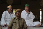 Muslim priests talk as a policeman stands guard at Ajmer Sharif, the shrine of Sufi saint Khwaja Moinuddin Chishti, where Pakistani president Asif Ali Zardari will visit Sunday, in Ajmer, in India's western state of Rajasthan, Saturday, April 7, 2012.