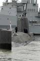 ailors aboard the Royal Navy submarine HMS Astute (S119) stand in formation topside as the ship is maneuvered into position upon its arrival at Naval Station Norfolk.