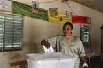 A woman casts her vote for president next to a Senegalese flag, in a school classroom serving as a polling station, in the Pikine suburb of Dakar, Senegal on election day, Sunday, Feb. 26, 2012. Polling stations have closed and election monitors in Senegal are now counting ballots from a vote that has tested the nation's image as one of the continent's oldest and most robust democracies. Sunday's election follows weeks of protests after the country's highest court ruled 85-year-old President Abd