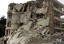 In this photo released by the Syrian official news agency SANA, a Syrian man, left, stands in front of a building that was damaged after two bombs exploded near a military compound, in the city of Idlib, northwestern Syria, Monday, April 30, 2012.