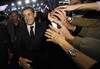 France's President and candidate for re-election in 2012, Nicolas Sarkozy, shakes hands with supporters as he leaves the meeting in Villepinte, east of Paris, Sunday, March 11, 2012.