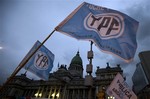 Supporters of an oil nationalization bill proposed by Argentina's President Cristina Fernandez holds up flags reading in Spanish "Fight and return YPF" outside Congress as senators debate the bill in Buenos Aires, Argentina, Wednesday, April 25, 2012.