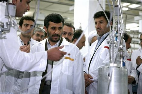 Iranian President Mahmoud Ahmadinejad, center, listens to a technician during his visit of the Natanz Uranium Enrichment Facility some 200 miles (322 kilometers) south of the capital Tehran, Iran