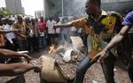 Cocoa growers protest an export ban by burning sacs of cocoa beans in front of the European Union office in Abidjan, Ivory Coast, Thursday, Feb. 17, 2011. Ivory Coast's biggest bank shut down its operations Thursday, joining the companies fleeing the country's deepening political crisis, as hundreds of growers in the world's largest cocoa exporter burned their beans in protest.