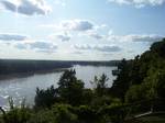 A wide river flows between dark forests and low bluffs.A relatively undeveloped reach of the river near Roche port, Missouri.